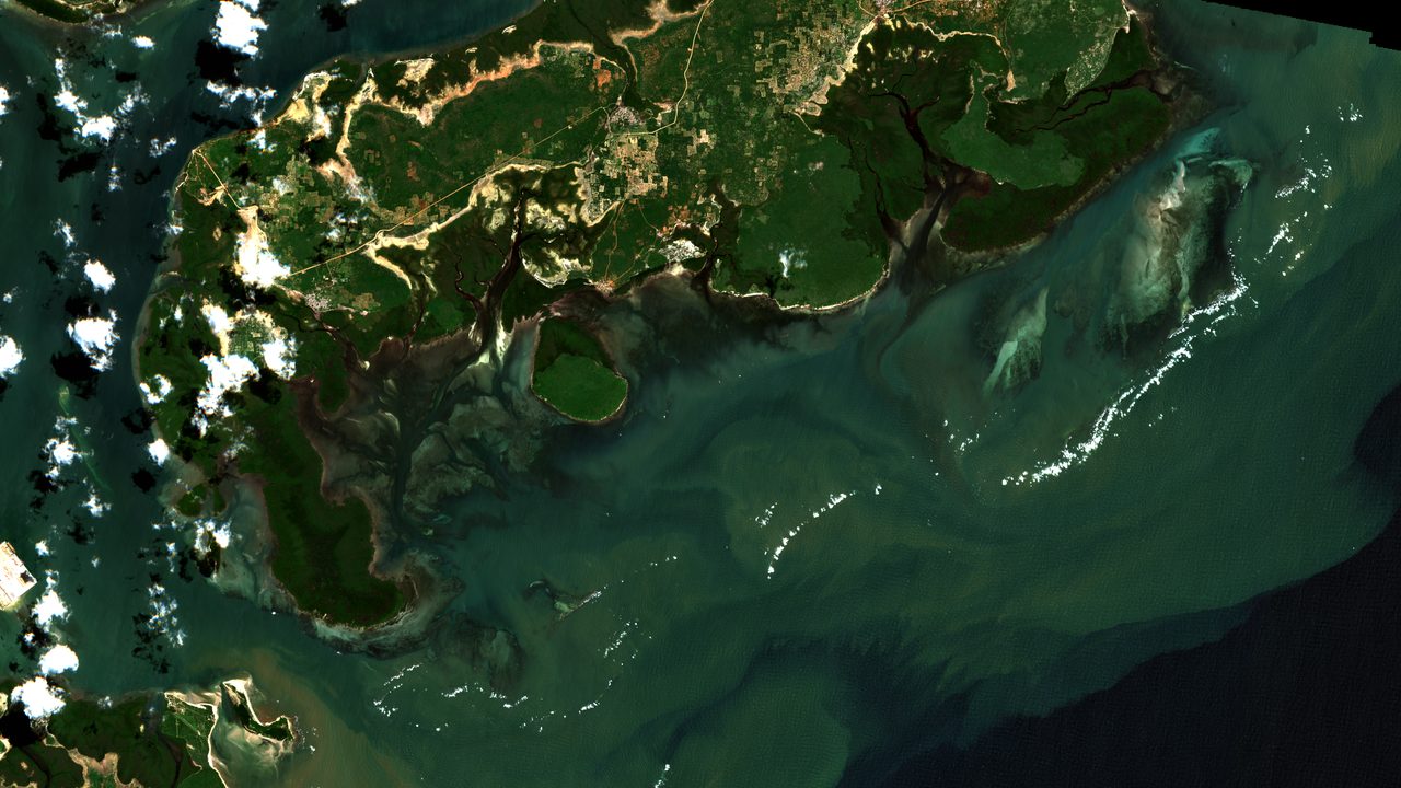 Sentinel-2 true-colour view of the northern Lamu archipelago coast in Kenya on 27 June 2026: dark green mangrove shore cut by inlets, turquoise shallow water and sediment swirls, with small white clouds and their shadows.