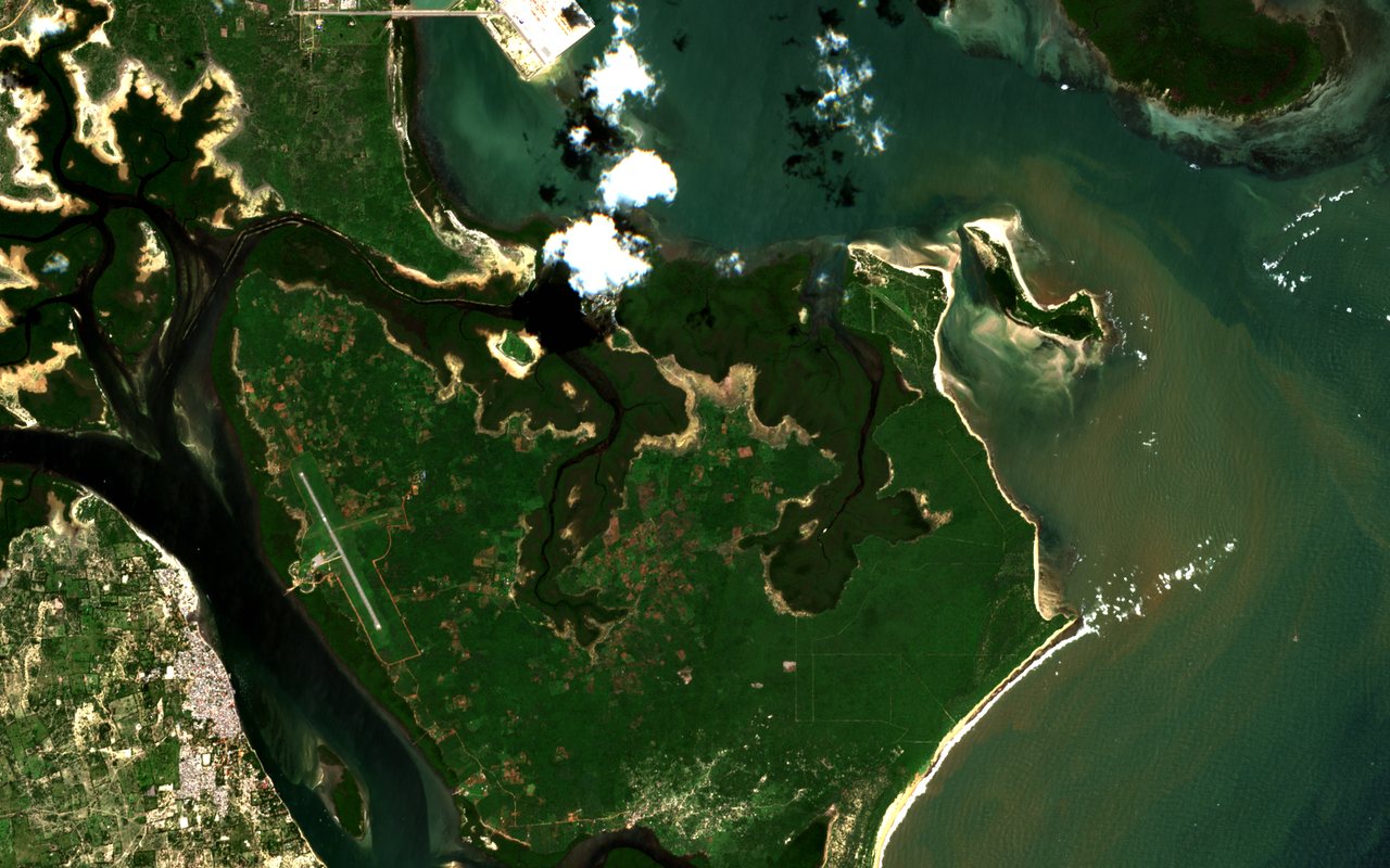 Sentinel-2 true-colour view of the Lamu archipelago in Kenya taken on 27 June 2026: green mangrove and scrub land on Manda Island with the grey strip of the Manda airstrip, the dense roofs of Lamu town across a narrow channel at the lower left, and brown sediment in the shallow water to the east and south.