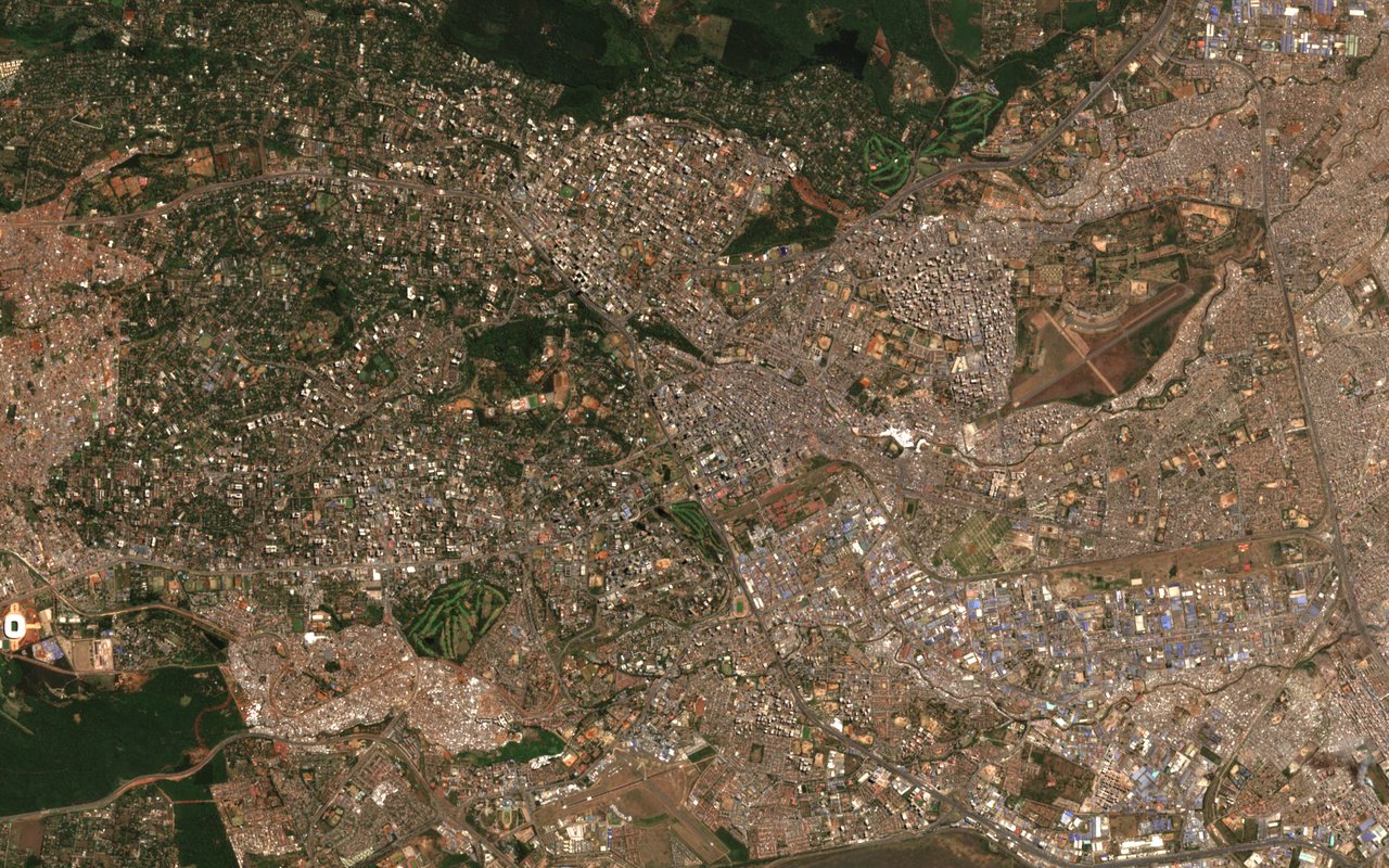 Sentinel-2 true-colour view of central Nairobi, Kenya, on 12 August 2026: dense neighbourhoods, green parks and golf courses, the runways of Wilson Airport near the bottom of the frame and large warehouse roofs. The sky is clear.