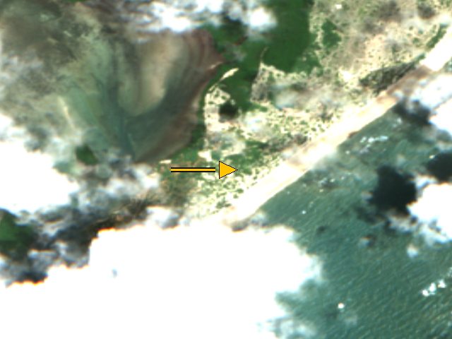 Sentinel-2 true-colour crop centred on the stored coordinate for Kiwayu, Kenya, acquired 2026-10-15. An arrow marks that stored point. Whole-scene cloud cover is 21.1 percent. This is a catalog crop, not a surveyed map and not a flight.