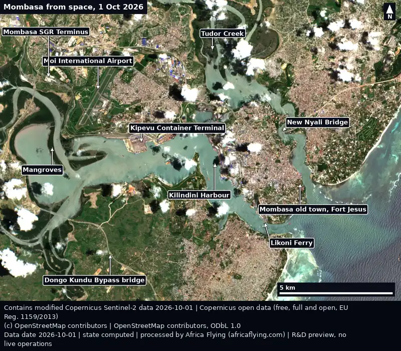 Sentinel-2 true-colour view of Mombasa, Kenya, on 1 October 2026, with labelled arrows to Kilindini Harbour, Tudor Creek, the old town and Fort Jesus, Likoni Ferry, Moi International Airport, the SGR terminus, the Kipevu container terminal, the Dongo Kundu bypass bridge, mangroves and the New Nyali Bridge. Some small clouds.